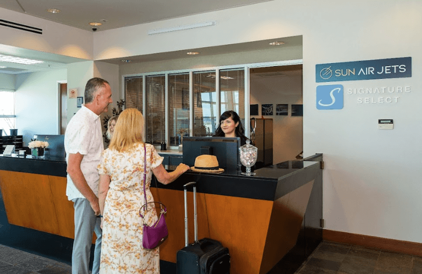 husband and wife at check in desk for empty leg charter flights