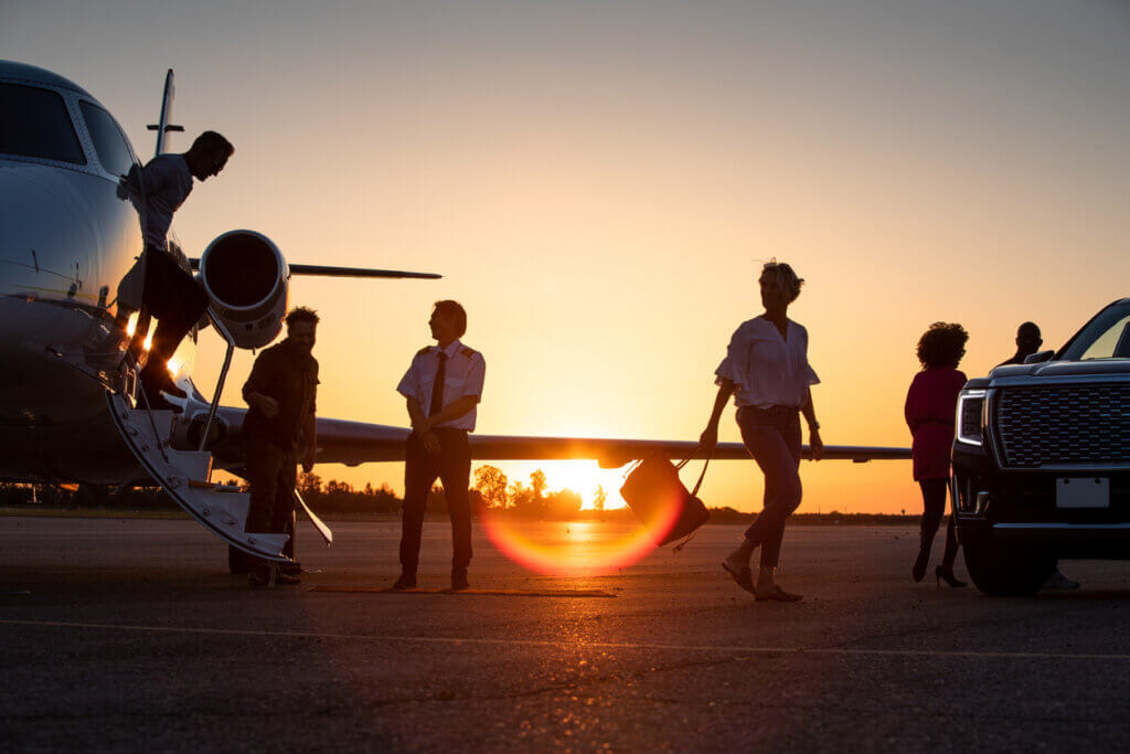 group of people near private jet after asking how many people can fit on a private jet